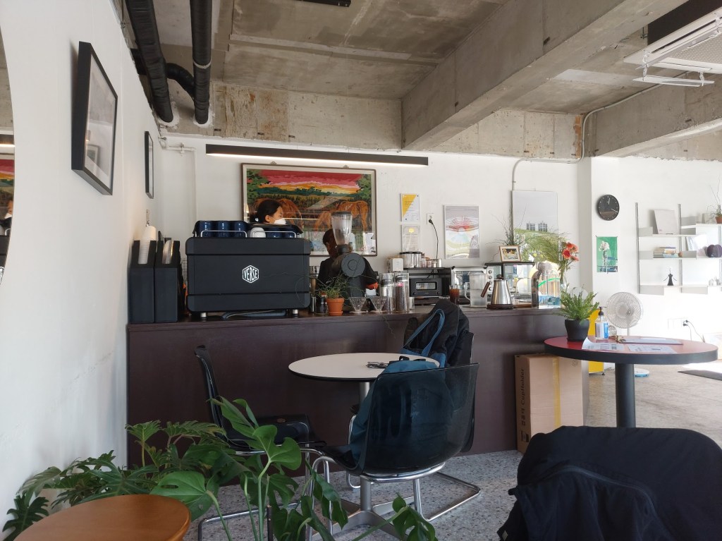 A black espresso machine behind a counter in the corner of the café 