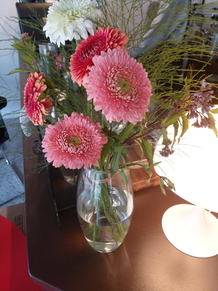 Some pretty pink flowers in a vase on the counter