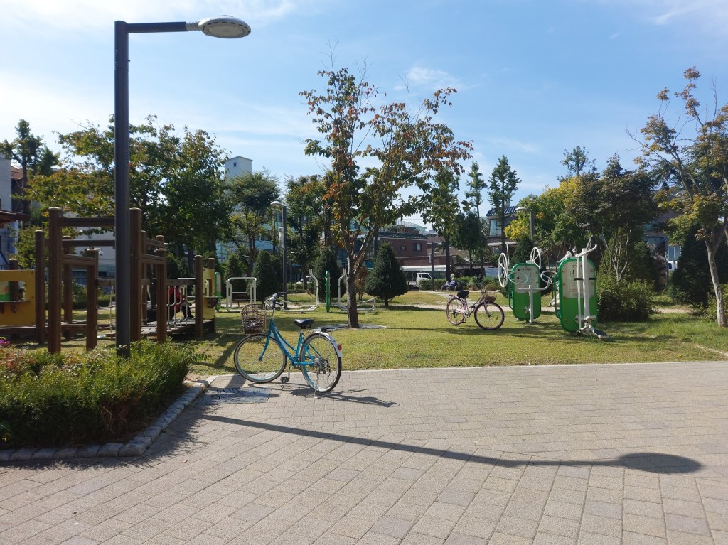Another view of the park across the street, where you can see bicycles and outdoor exercising equipment