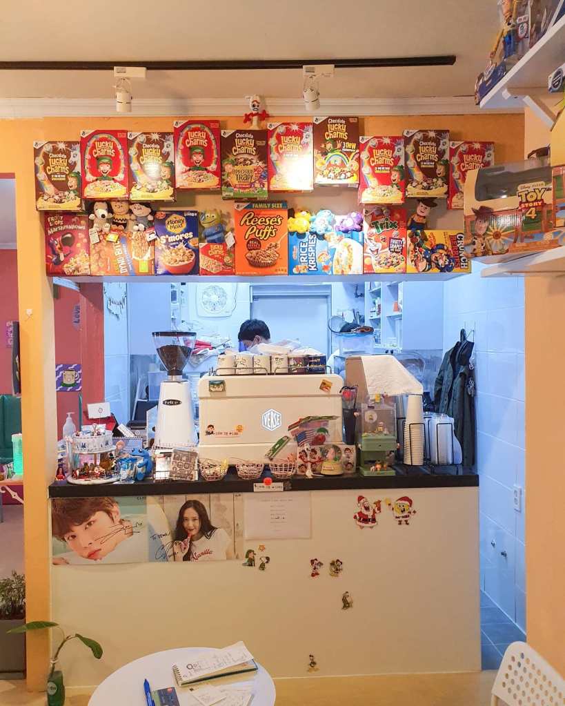 The back of the espresso machine, surrounded by a wall full of empty cereal boxes